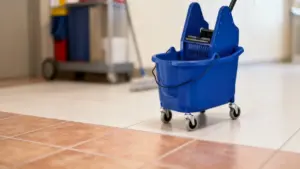 Secchio per la pulizia con strizzatore su pavimento piastrellato