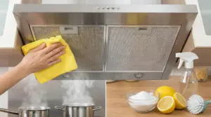 Una mano pulisce la cappa della cucina con un panno giallo accanto a limone, bicarbonato e spray naturale