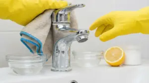 Rubinetto con incrostazioni di calcare pulito con rimedi naturali come limone e bicarbonato